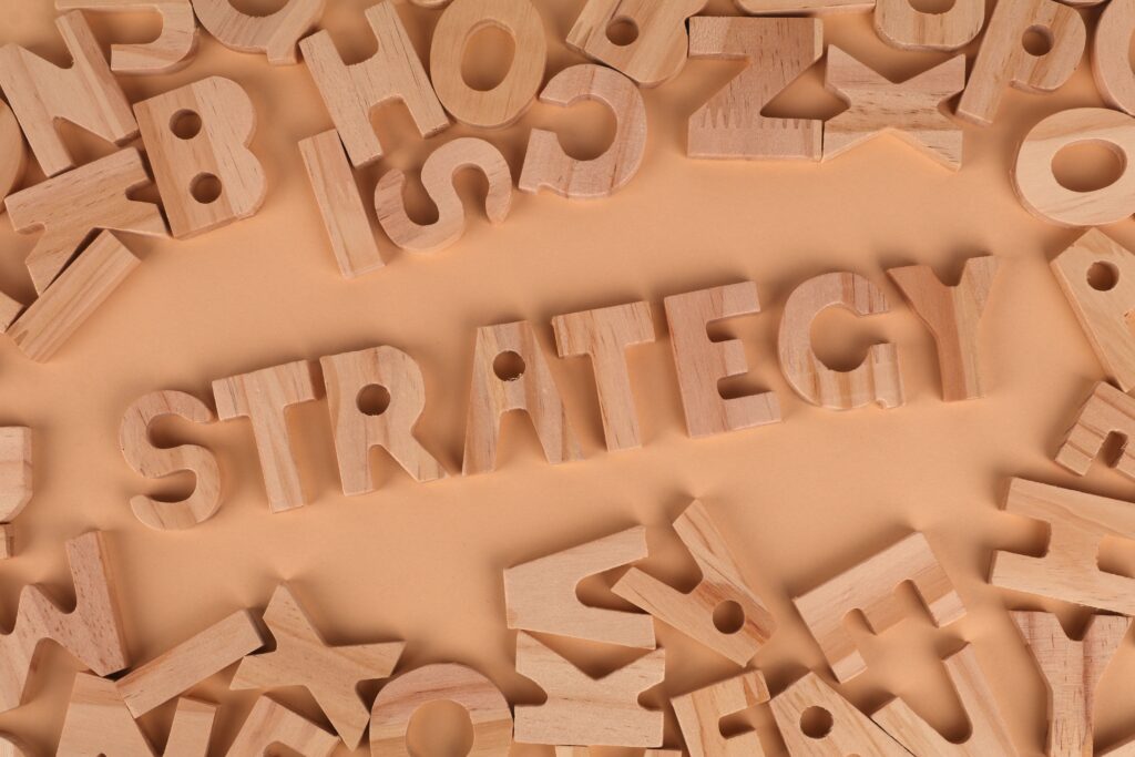 Assorted wooden alphabet letters scattered on a peachy background.